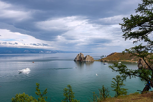 Veliko jezero s nekoliko brodica i dvije izražene stijene koje vire iz vode.