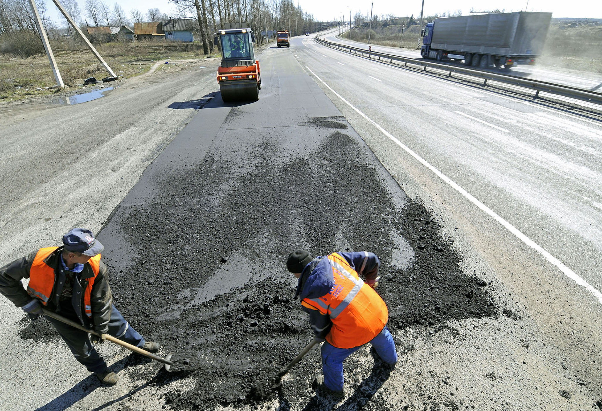 Fotografija prikazuje radnike koji postavljaju asfalt na cestu. Ostatak nakon frakcijske destilacije građen je od ugljikovodika vrlo velike molekulske mase (40 C-atoma). Nakon vakuumske destilacije zaostaje bitumen ili asfalt, koji se koristi za asfaltiranje cesta i izolaciju.