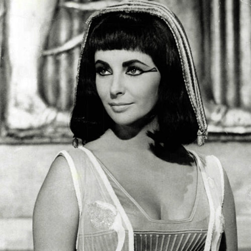 Elizabeth Taylor utjelovila je na filmu Kleopatru. Na slici je prikazana kao žena poluduge crne kose sa šiškama koja naglavi nosi jednostavno pokrivalo. Posebno su izražajne oči iscrtane crnom bojom koja se nastavlja od vanjskih kutova očiju prema vanjskom dijelu lica.