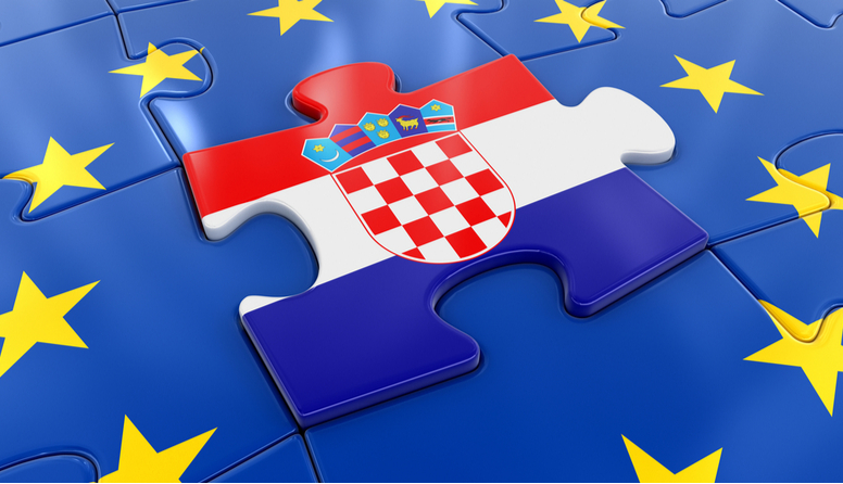 Ilustracija puzzli.Središnja puzzla ima sliku hrvatske zastave. Okolne puzzle su plave s žutim zvijezdicama i spojene predstavljaju zastavu europske unije.