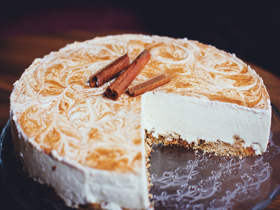 Torta koja ima bijelu kremu i cimet na vrhu.