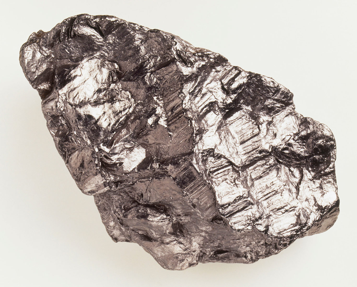 Fotografija prikazuje komad grafita, čvrste tvari sivo-crne boje i blagog metalnog sjaja.