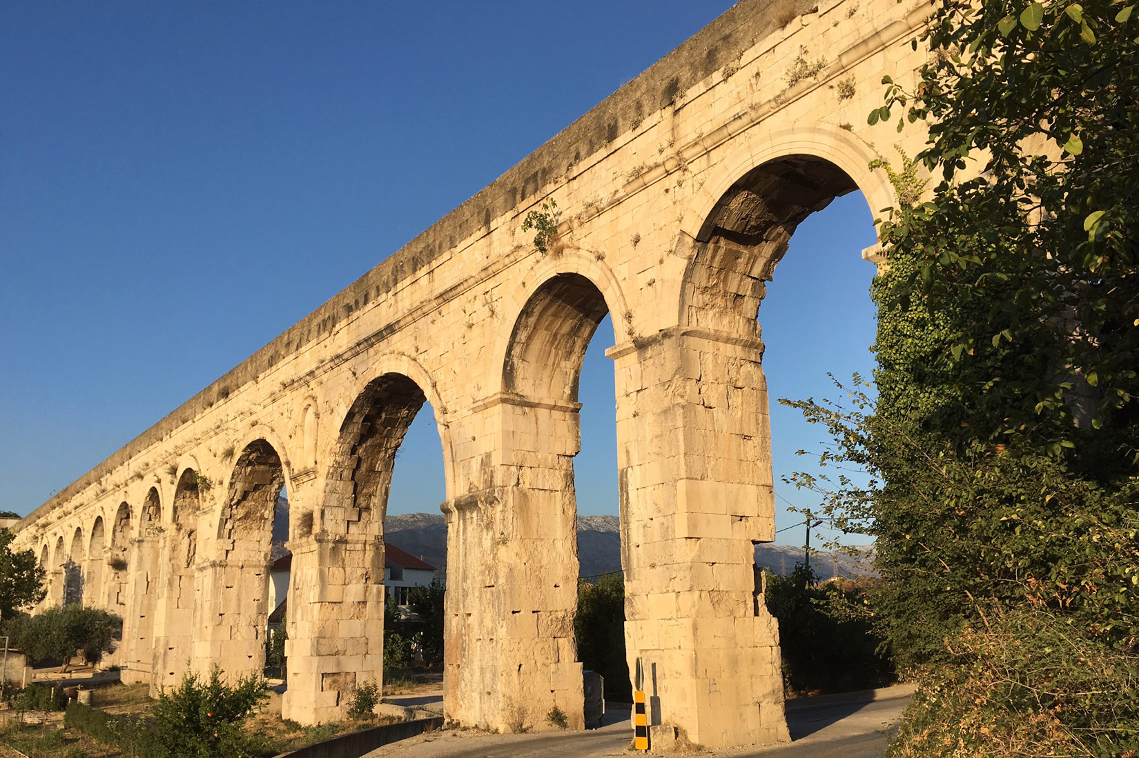 Na fotografiji je prikazan Dioklecijanov akvadukt. Za vrijeme Rimljana vodio je vodu. Izgrađen je od žutih kamneih blokova u obliku lukova. Visok je kao most.