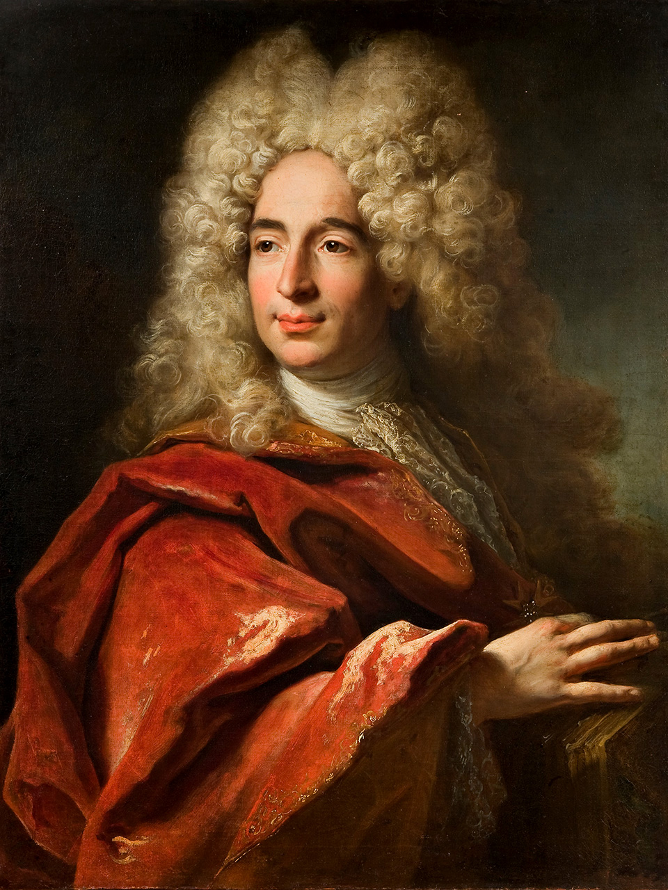 Muškarac s vlasuljom iz 17. st. zaogrnut crvenim plaštem. 