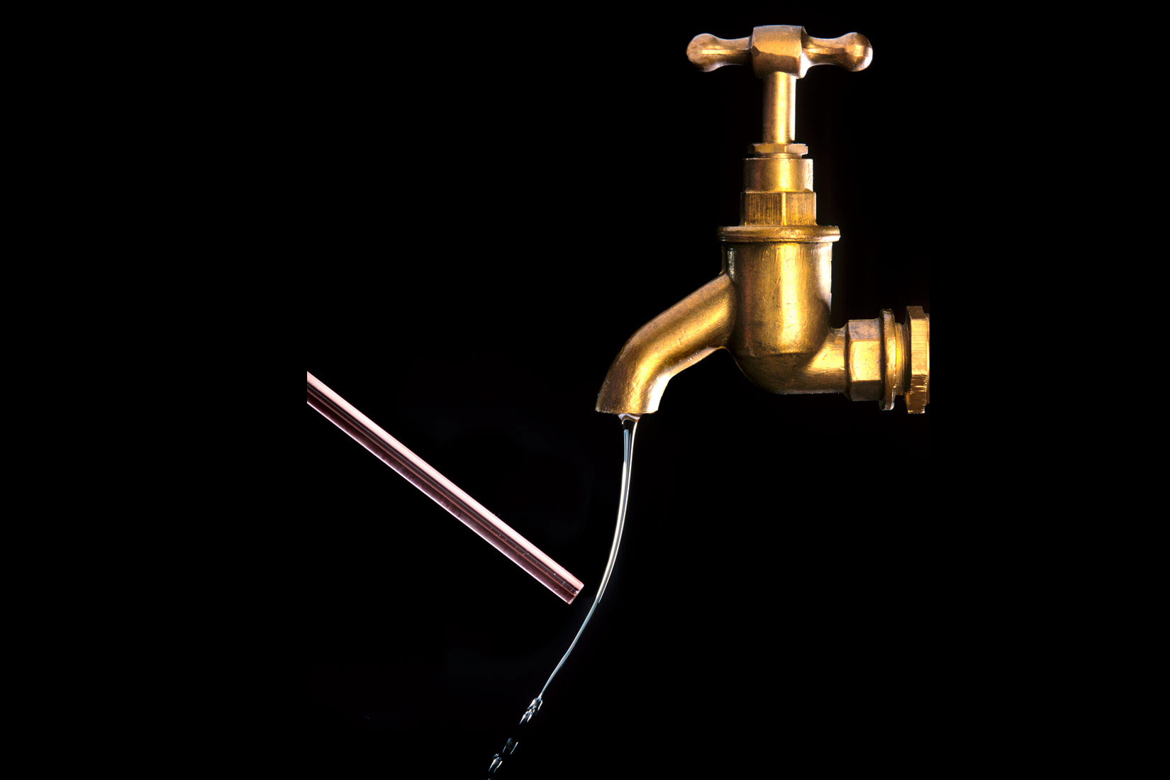 Prikaz otklona mlaza vode koji teče iz slavine.Podloga je crna, a slavina zlatno-bakrene boje.