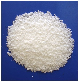 Fotografija prikazuje uzorak stearinske kiseline koja izgleda poput krupne soli.