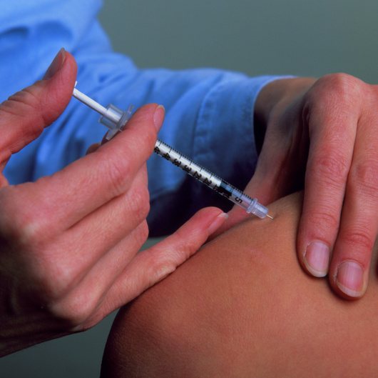 Prikazano je ubrizgavanje injekcije inzulina kojeg liječnik daje pacijentu pomoću tanke šprice s iglom na vrhu.