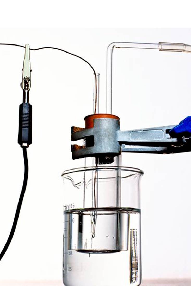 Fotografija prikazuje standardnu vodikovu elektrodu uronjenu u čašu vode koju stabilizira držač.