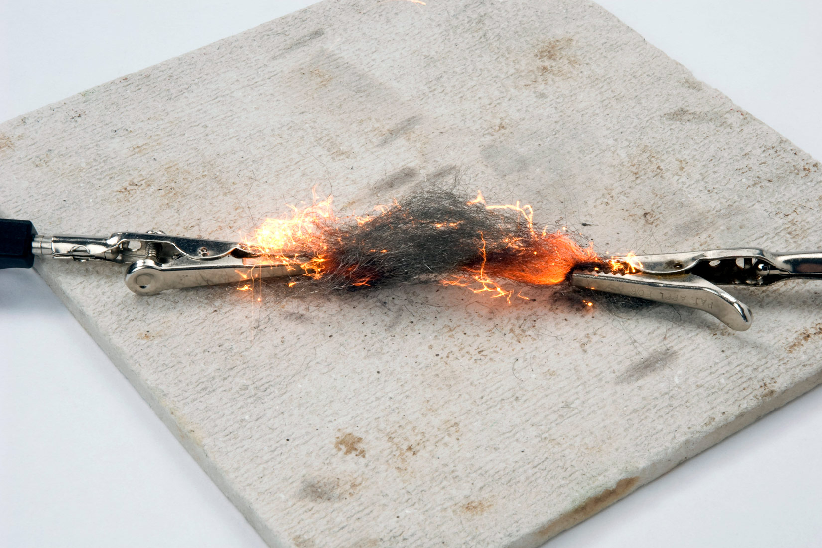 Na slici je prikazan prolazak struje kroz čeličnu vunu. Sa svake strane čelične vune prikvačene su male metalne kleme u obliku štipaljki. Uz rubove klema stvara se žar narančaste boje koji nastaje zagrijavanjem vune. Kleme su postavljene na keramičku bijelu pločicu kvadratnog oblika.