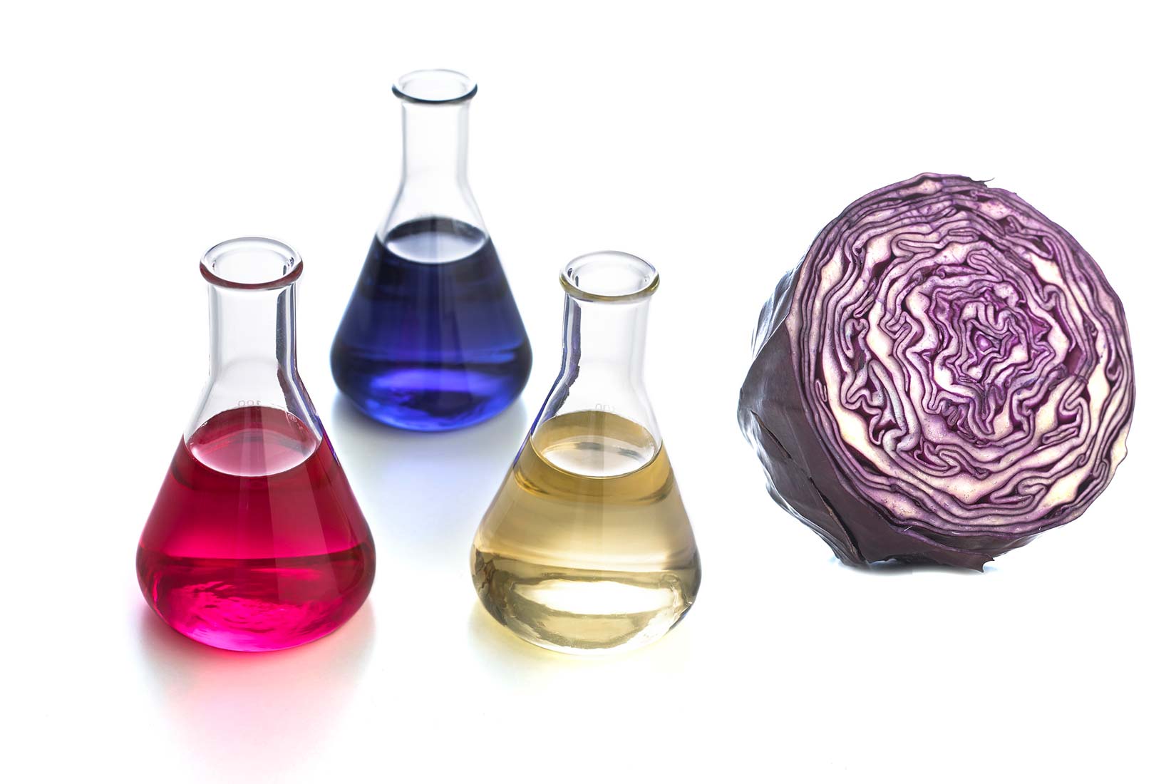 Na slici je prikazana polovica crvenog kupusa i tri Erlenmeyerove tikvice. U jednoj je crvena tekućina, u drugoj žuta, a u trećoj plava.Sok crvenog kupusa je prirodni indikator koji u kiselni pocrveni a u lužinama požuti.