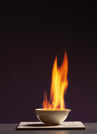 Slika prikazuje gorenje etanola u keramičkoj zdjelici. Etanol gori narančastim plamenom.