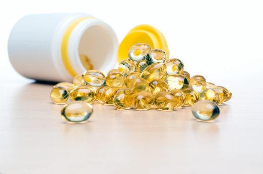 Na fotografiji su kapsule koje u svom sastavu sadrže riblje ulje. Ovalnog su oblika, prozirne sa žućkastim dijelovima.