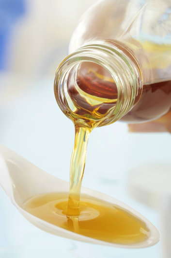 Fotografija prikazuje kukuruzni sirup, gustu tekućinu zlatnožute boje.