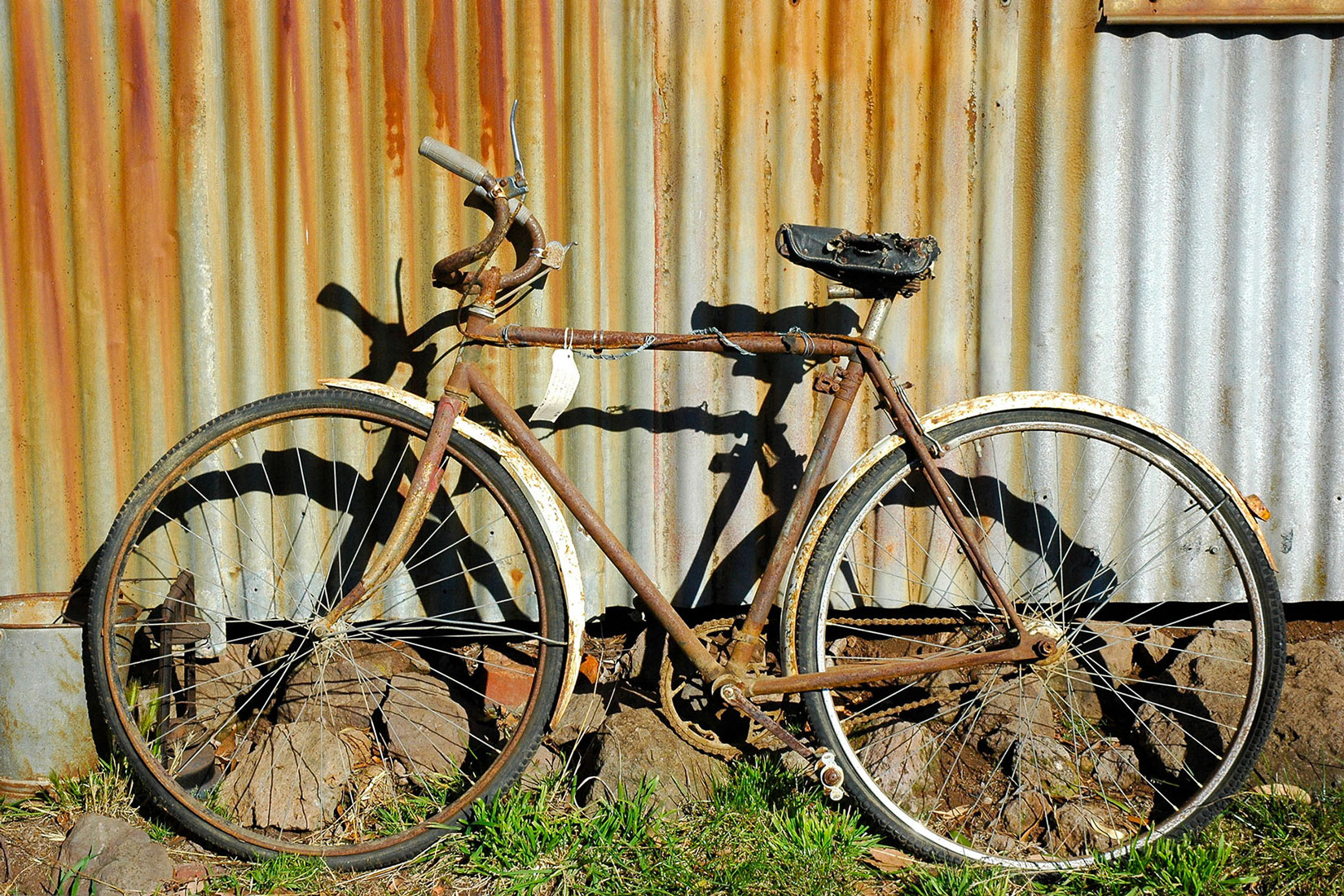 Fotografija prikazuje bicikl koji je bio izložen koroziji, stoga su svi njegovi dijelovi zahrđali.