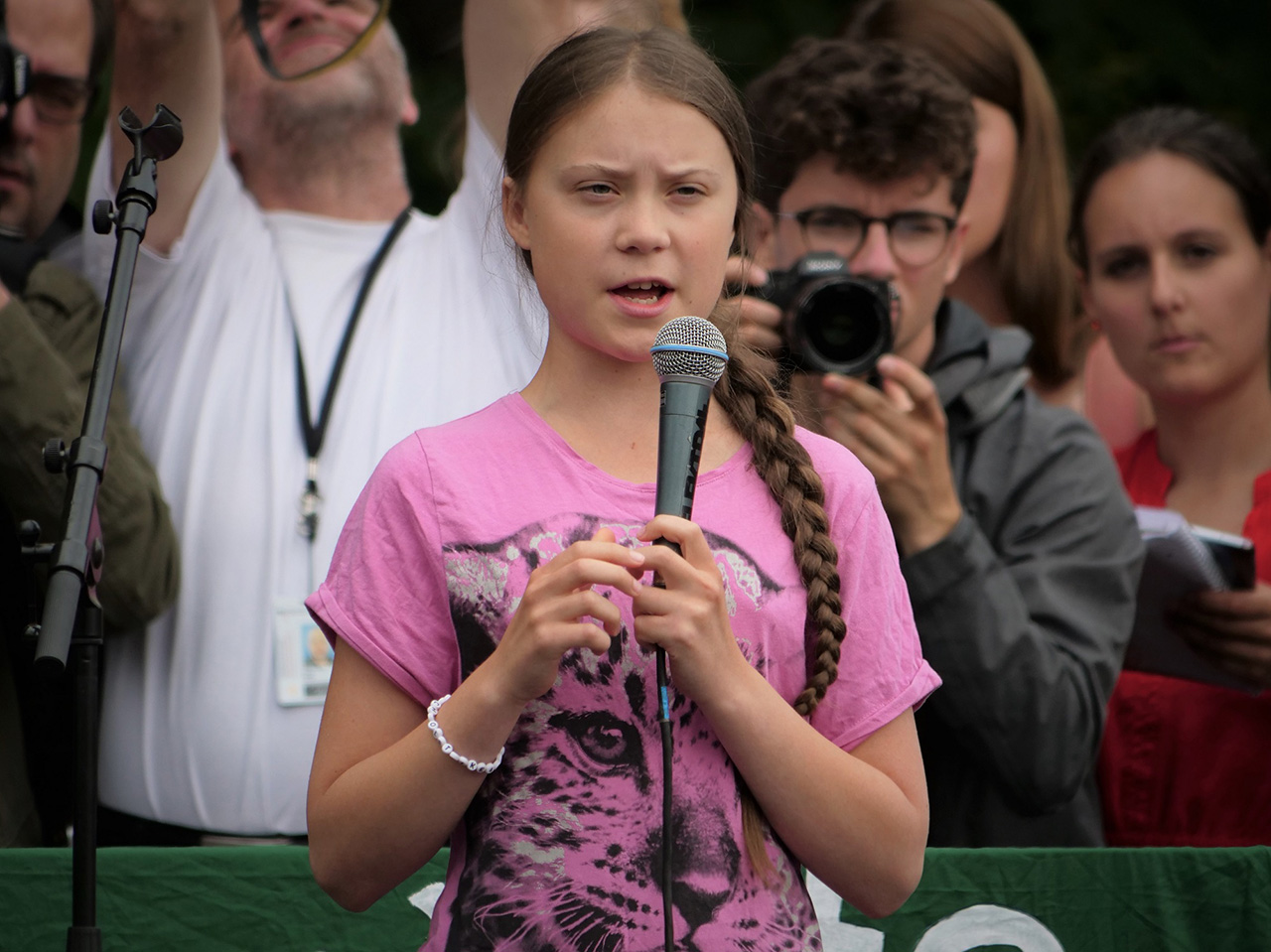 Greta Thunberg drži govor kojeg u pozadini prati mnoštvo fotoreportera.