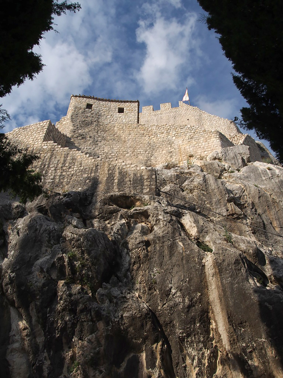 Utvrda na stijeni fotografirana iz podnožja. 