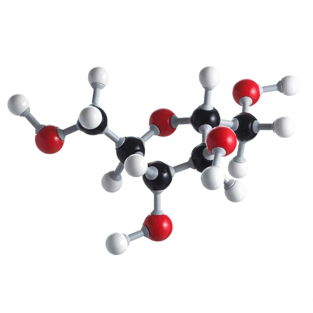 Fotografija prikazuje model molekule fruktoze načinjen od kuglica štapića. Šest atoma ugljika prikazano je crnim kuglicama, pet atoma kisika crvenim, a 12 atoma vodika bijelom bojom.